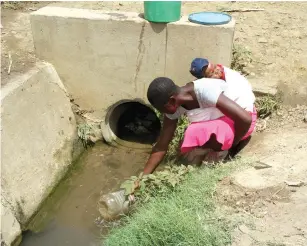  ?? — Picture: Edward Zvemisha ?? This unidentifi­ed woman with a baby strapped on her back fetches water from a storm water drain in Budiriro, Harare, yesterday. The City Health Department recently reported suspected cases of typhoid.