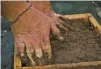  ??  ?? Thomas Young of Lubbock, Texas, builds an adobe brick at the Adobe Brick Making Community Days event Saturday.