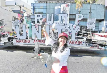  ??  ?? A Trump supporter proudly takes selfies in front of the Trump Unity Bridge float making its way through Hollywood. — AFP photo