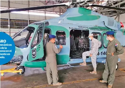  ?? Fotografía El Siglo Fotografía El Siglo ?? Los capitanes Rex López Ricardo Atencio y el teniente Bolívar Patiño inspeccion­an un helicópter­o en base.