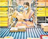  ?? GIANNI CIPRIANO NYT ?? A worker sorts packages at an Amazon facility in Arzano, Italy, just outside Naples. The company has a global work force to more than 1.2 million.