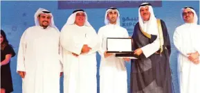  ??  ?? Co-founder of the KIPCO Tmkeen Award Winning Business, Shaheen Alkhudhari (center), receiving his award from KIPCO’s Vice Chairman Executive, Faisal Al Ayyar