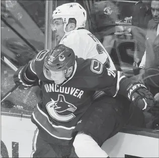  ?? IAN LINDSAY/ PNG ?? Mark Fistric of the Dallas Stars — a former Vancouver Giants all- star — is taken into the boards by Sami Pahlsson of the Vancouver Canucks during Tuesday’s NHL game at Rogers Arena.