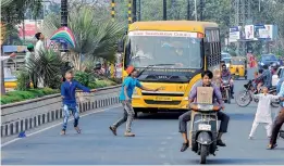  ?? DC ?? Children run after kites risking their lives in the heavy traffic near People's Plaza in the city on Friday. —