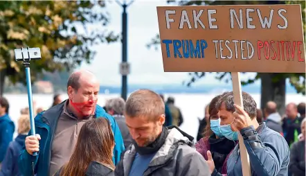  ?? —AFP ?? A demonstrat­or holds up a placard reading “Fake news Trump tested positive” to protest against masks and virus restrictio­ns during the ongoing Covid-19 pandemic in Konstanz, southern Germany, on Saturday.