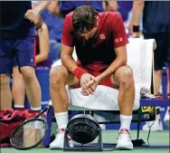  ?? JASON DECROW / AP ?? Roger Federer cools down in front of an electric fan during a changeover in his fourth-round US Open match against John Millman on Tuesday. Australian Millman caused a huge upset by ousting the Swiss great 3-6, 7-5, 7-6 (7), 7-6 (3).