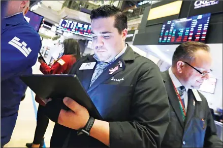  ?? (AP) ?? Trader Joseph Lawler (center), works on the floor of the New York Stock Exchange on Jan 28. Stocks are opening broadly higher on Wall Street a day
after the S&P 500 had its biggest drop since early October. Technology companies were putting up some of the biggest gains early Tuesday.