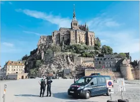  ?? DENIS SURFYS THE ASSOCIATED PRESS ?? Police oversee the evacuation at Mont Saint-Michel, on France's northern coast, Sunday.