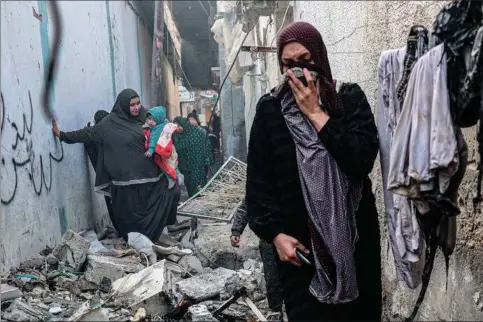  ?? Foto: Said Khatib/AFP ?? Kvinder går igennem ruinerne i Rafah i det sydlige Gaza, efter at Israel har bombet i løbet af natten.