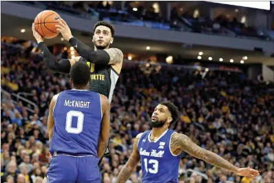  ?? AP Photo/Aaron Gash ?? Marquette’s Markus Howard is called for a charging foul against Seton Hall’s Quincy McKnight on Feb. 29 in Milwaukee.