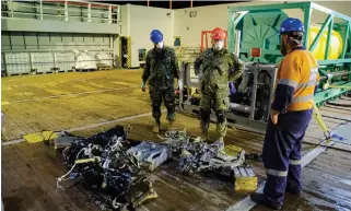  ?? CMDR. ROBERT WATT
DEPARTMENT OF NATIONAL DEFENCE ?? Canadian Armed Forces members inspect recovered parts of the helicopter Stalker 22 during recovery operations for the aircraft in the Mediterran­ean Sea on Sunday.