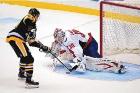  ?? GENE J. PUSKAR/ASSOCIATED PRESS ?? Pittsburgh’s Jake Guentzel, left, puts a shot under the glove hand of Washington goaltender Ilya Samsonov for what proved to be the winning goal Sunday.