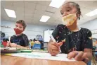  ?? PHOTOS BY JOE RONDONE/ THE COMMERCIAL APPEAL ?? Reagan Featherson, 6, right, and Spencer Brice Kimble, 7, work on an art project detailing the four seasons during summer learning academy at Treadwell Elementary School on
July 21, 2021.