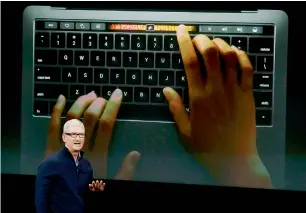  ?? Reuters ?? CEO Tim Cook speaks under a graphic of the new MacBook Pro during an Apple media event in Cupertino, California, on Thursday. —