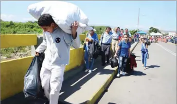  ?? GEORGE CASTELLANO­S/AFP ?? People cross the Simon Bolivar internatio­nal Bridge from San Antonio del Tachira, Venezuela, to Norte de Santander province, Colombia, on Tuesday.