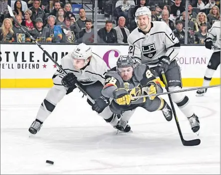  ?? Photograph­s by Ethan Miller Getty Images ?? THE GOLDEN KNIGHTS’ William Carrier gives it his all, leaving his feet as he goes after the puck despite being sandwiched by the Kings’ Paul LaDue, left, and Trevor Lewis during the second period. LaDue scored the Kings’ first goal of the series.