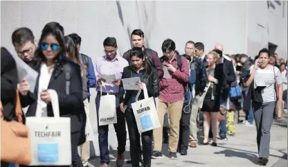  ??  ?? People wait in line to attend TechFair LA, a technology job fair, in Los Angeles, California. — Reuters