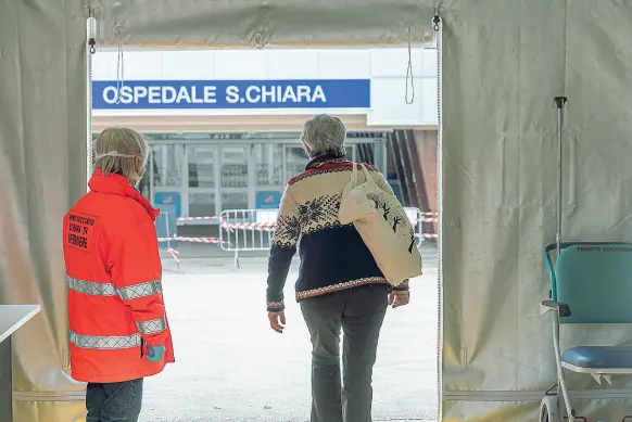  ??  ?? Primo accesso Il tendone del pre-triage posto nel piazzale dell’ospedale Santa Chiara di Trento. Una infermiera pone domande agli utenti che si presentano