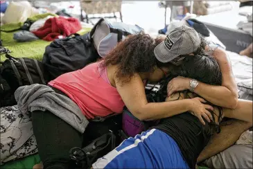  ?? JAY JANNER / AMERICAN-STATESMAN ?? A displaced family hugs upon their arrival at the shelter at St. Thomas Presbyteri­an Church in West Houston on Tuesday. Thousands of flood victims have found temporary homes at shelters. St. Thomas opened its doors mainly to flood victims who live...