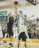  ?? Andy Cross, The Denver Post ?? Rock Canyon guard Sam Masten and ThunderRid­ge forward Austin Mueller battle for a loose ball in the second half of Friday night’s game.