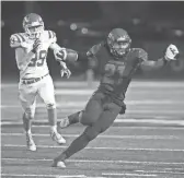  ?? CHERYL EVANS/THE REPUBLIC ?? Chaparral’s Jared Williams (21) attempts to avoid Brophy’s Josh Minton while carrying the ball during a game at Chaparral High on Friday night. Chaparral won 35-0.