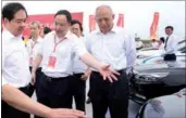 ?? PROVIDED TO CHINA DAILY ?? Yu Jun (center), general manager of GAC Motor Co, introduces car models to guests in Hangzhou, Zhejiang province, on Wednesday.