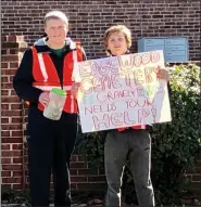  ?? PHOTO BY SANDI YANISKO/THE HILL SCHOOL ?? Hill School students Colin Brown and Jake Craig helped to collect pocket change from passing drivers to benefit Edgewood Cemetery.