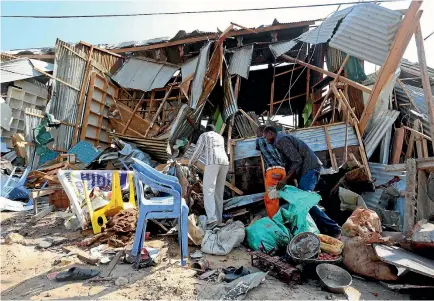  ?? PHOTO: REUTERS ?? Traders attempt to salvage their goods at the scene of a suicide bomb explosion at the Wadajir market in Madina district of Somalia’s capital Mogadishu.