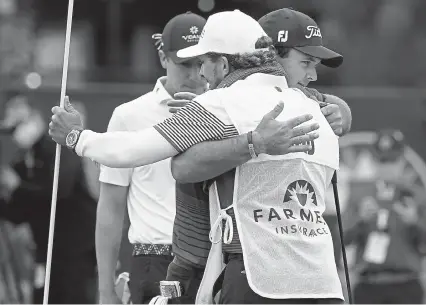  ?? Gregory Bull, The Associated Press ?? Patrick Reed, facing right, hugs his caddie, Kessler Karain, after putting on the 18th hole to win the Farmers Insurance Open golf tournament at Torrey Pines on Sunday in San Diego.