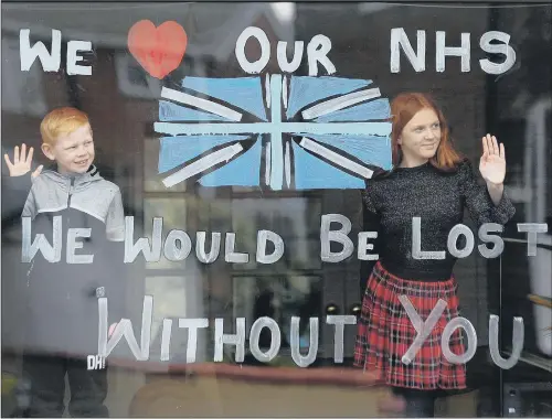  ?? PICTURE: SIMON HULME ?? SAYING THANKS: Daniel and Lydia Hardwick, of Oulton, Leeds, with the message they have painted on their front window in support of the NHS.