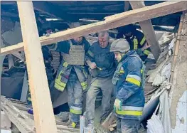  ?? Ukrainian Emergency Service ?? EMERGENCY WORKERS assist a wounded man after houses were badly damaged in a Russian missile attack near Kryvyi Rih in central Ukraine.