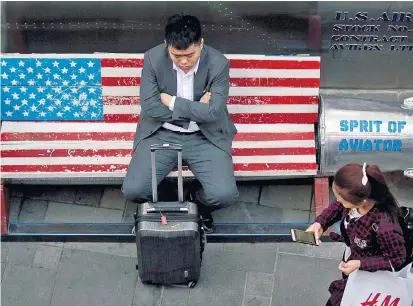  ??  ?? Irgendwie symbolisch: Ein Passant in Peking ruht sich vor einem American-Apparel-Store aus.