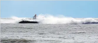  ?? DAVE JOHNSON THE WELLAND TRIBUNE ?? With the foghorn in the background, waves break over the western end of the breakwall Wednesday in Port Colborne. High winds created a seiche in the eastern end of Lake Erie.