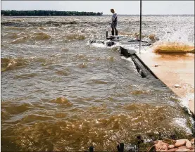  ?? JEREMY WADSWORTH / THE (TOLEDO) BLADE ?? Phil Edwards stands on the immersed dock at his Sandusky Bay home June 10 in Marblehead.