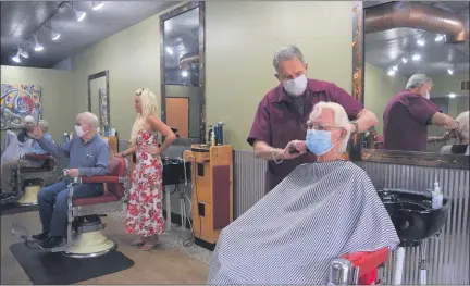  ?? MITCH HOTTS — THE MACOMB DAILY ?? Bill Visnaw works on the hair of his cousin, Tom Barton, while Julia Miracle prepares to cut the hair of Barton’s brother Bruce in the next chair. Gloria Lipka, the third barber down, is busy with her customer John Blohm of Mount Clemens.