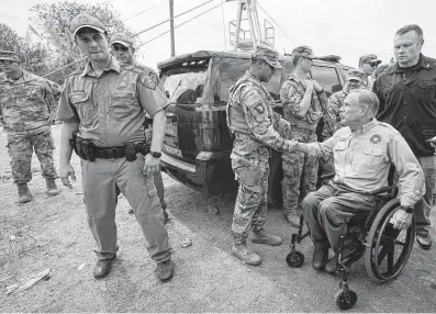  ?? Julio Cortez / Associated Press ?? Gov. Greg Abbott shakes a National Guard member’s hand after a Sept. 21 news conference in Del Rio while federal officials were flying Haitians back to their homeland and blocking others from crossing the border.
