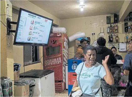  ?? BLOOMBERG ?? Atentos. Los brasileños siguieron los resultados de la elección por TV. El recuento fue muy rápido.