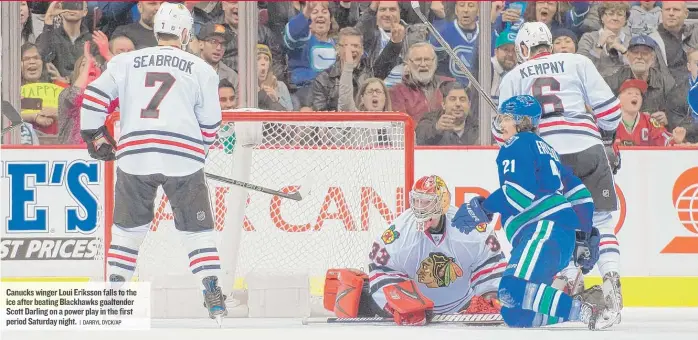  ??  ?? Canucks winger Loui Eriksson falls to the ice after beating Blackhawks goaltender Scott Darling on a power play in the first period Saturday night.
| DARRYL DYCK/ AP