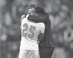  ?? LAURENCE GRIFFITHS/GETTY IMAGES ?? England’s Bukayo Saka was consoled by coach Gareth Southgate after his penalty miss Sunday in the Euro 2020 final.