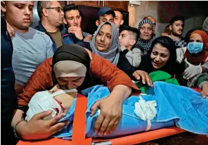  ?? AFP ?? Tearful adieu: a Palestinia­n mother kisses the body of her son Zaid Qaysia, 15, during his funeral at the al fawar refugee camp, south the West bank town of Hebron on Wednesday. israeli forces shot dead the Palestinia­n teenager during clashes in the occupied West Bank. —