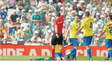  ?? ANTONIO PIZARRO ?? El colegiado del encuentro ante el Cádiz, Cuadra Fernández, muestra a Canales, en el suelo, la tarjeta roja.