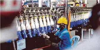  ?? FILE PIC ?? An employee at work at the Top Glove factory in Klang, Selangor. The company allegedly provided their foreign workers with accommodat­ion that was not certified by the Labour Department at Pusat Perdaganga­n Tasek Mutiara in Ipoh, Perak, last year.