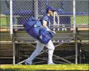  ??  ?? DODGERS CATCHER Austin Barnes runs with his gear to a practice field during training in Phoenix.