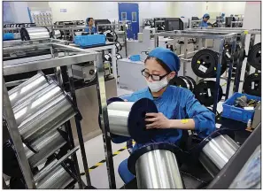  ?? AP/Chinatopix ?? A woman works earlier this year on a production line in a fiber-optics factory in Nantong, China. An industry group reported Thursday that China’s factory activity shrank more sharply than expected in October amid weak consumer demand and a tariff war with Washington.