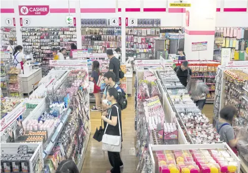  ??  ?? Customers browse through products at a Daiso store.