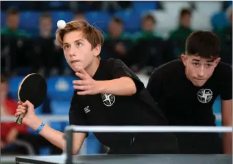  ??  ?? Petar Kokic from St. Brigids, Newbridge, Kildare, serves during the U16 Table Tennis Doubles final as team-mate Sean Cummins (right) stands poised for the return