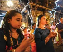  ?? — afp file ?? Devotees light oil lamps while offering prayers during New Year’s Day at a Hindu temple in Colombo on January 1, 2024.