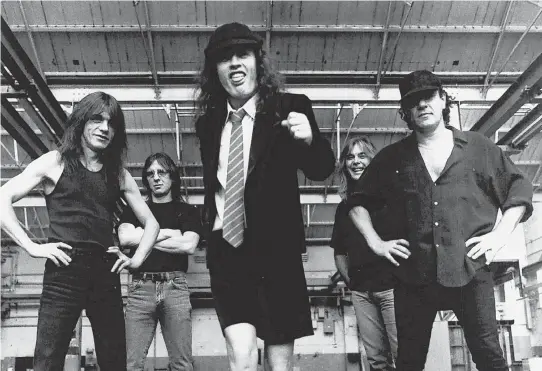  ?? AP PHOTO, TOP; COURTESY PHOTO, ABOVE ?? HITTING IT HARD: Guitarist Malcolm Young, pictured at top and above at left with AC/DC, is credited with being the band’s riff master and one of its most prolific songwriter­s.