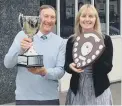  ?? ?? The new Lloyd Dowson Cricket Cup and runners-up shieldare handed over by Vanessa Rowbottomd to the president of the Evening League Andre Meunier