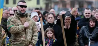  ?? Getty iMages ?? BURIAL: Christina Dragun holds her daughter Olya Siksoy during the burial for her husband, a Ukrainian soldier, Sunday in Lviv, Ukraine.